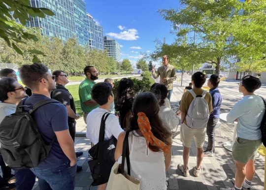 students outdoors visiting a development site in Boston Seaport with Lecturer Yanni Tsipis