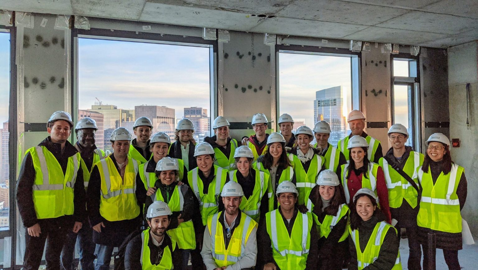 class photo of masters students touring alum Ollie carr's building under-development