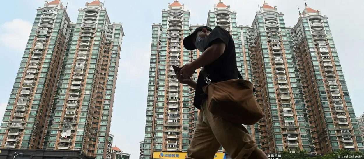 man walking in front of chinese apartment development